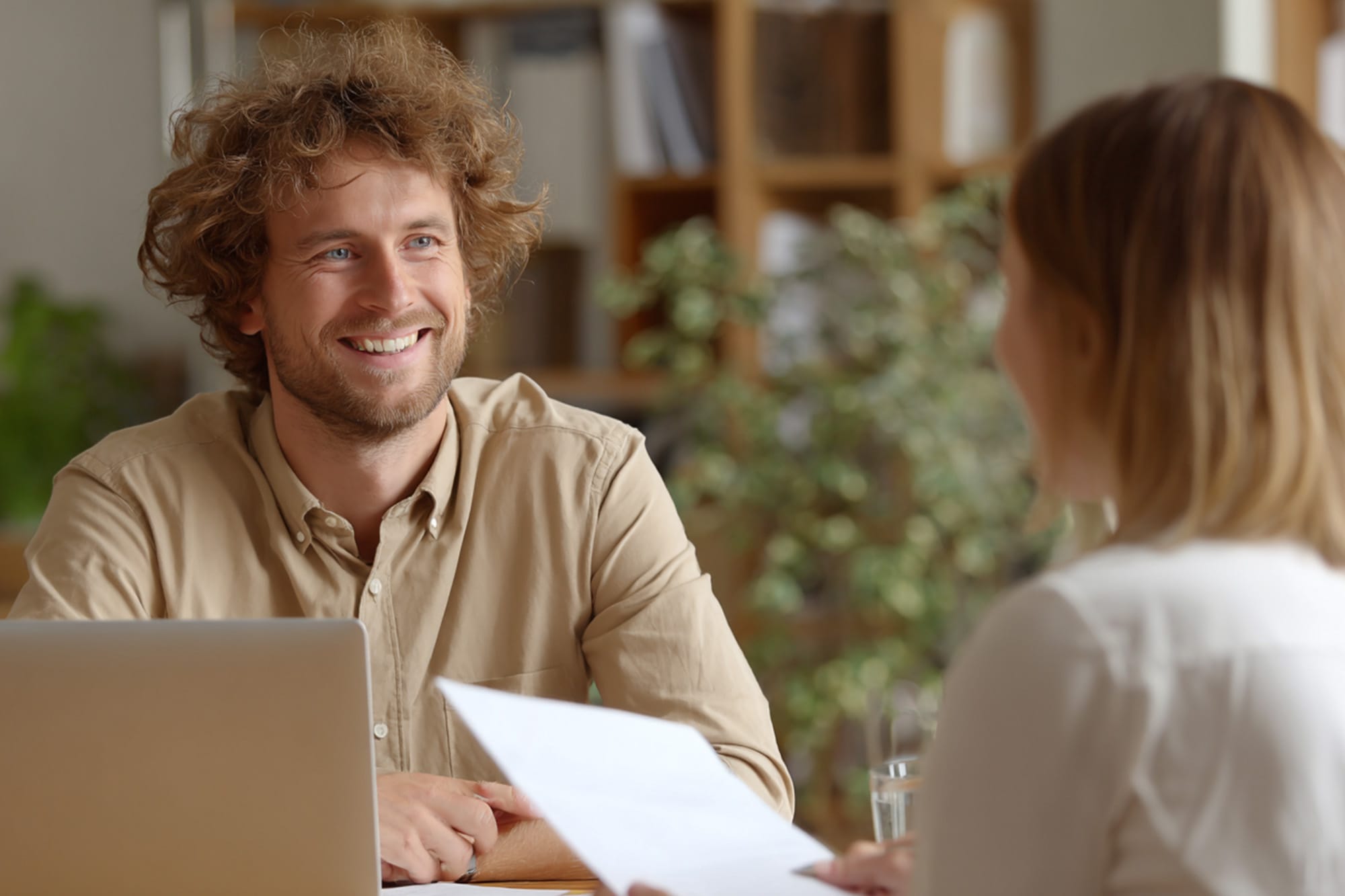 patient consulting with insurance specialist at desk, paperwork and laptop, warm professional environment, supportive mood