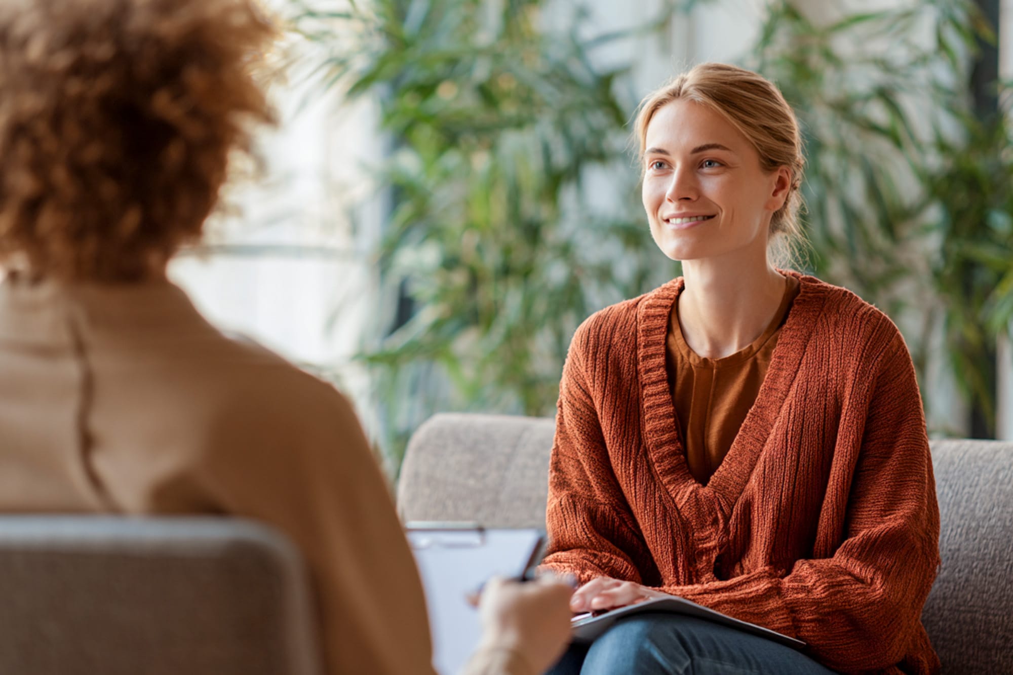 One-on-one therapy session, therapist listening attentively, calm neutral space, empathetic and professional tone